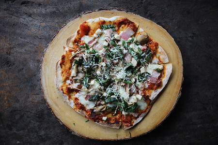 鲜美的意大利比萨饼在木披板上美味的意大利披萨在神秘的光辉视野下图片