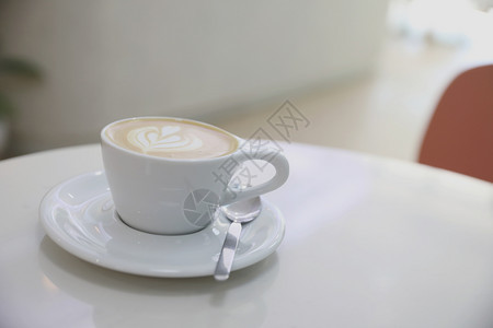 白色陶瓷杯里带花纹的咖啡图片