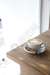 木桌上白色杯子里的咖啡图片