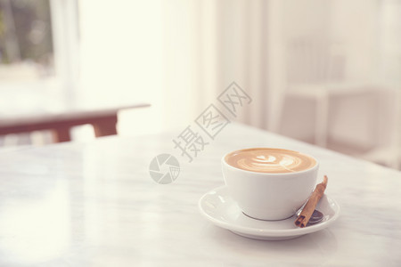 白色大理石桌上的卡布奇诺咖啡杯图片