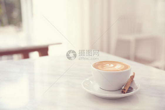 白色大理石桌上的卡布奇诺咖啡杯图片