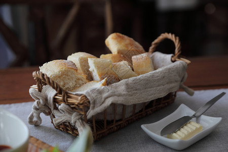 木制背景的篮子中法式面包图片