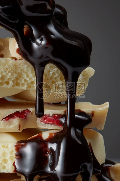 白色巧克力块和糖浆紧贴近葡萄糖浆倒在一块巧克力上图片