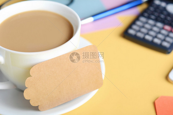 带有咖啡cokie和计算器的空白便笺纸黄色背景图片