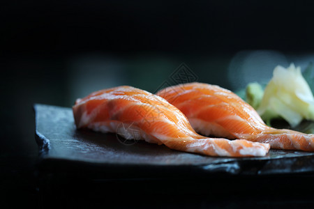 黑盘子上日本菜的三文鱼寿司图片