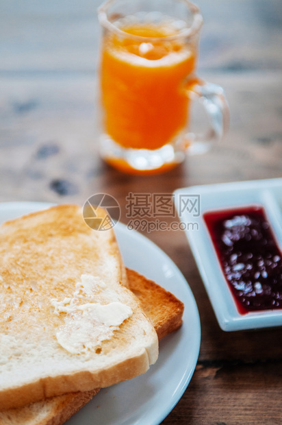 烤面包切片加黄油果酱和一杯橙汁图片