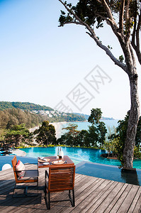 2014年3月8日014年泰国普吉在泳池旁边的晚餐桌有海景和美丽的大树在泰国普吉图片