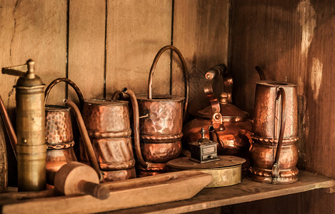 铜黄旧茶壶和木制橱柜中的罐头图片