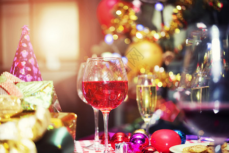 红香槟杯和礼物盒派对配件模糊的bokeh光背景圣诞快乐和新年庆典概念背景图片