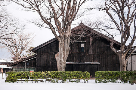 寒雪中古老的日本黑仓库高清图片