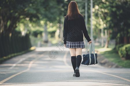 在公园户外电影陈年风格上行走的女学生服装肖像图片