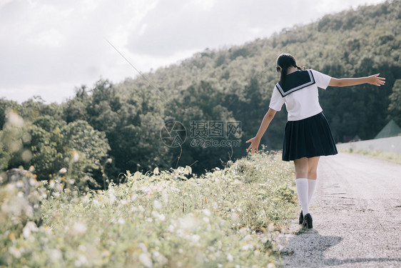 在公园户外电影陈年风格上行走的女学生服装肖像图片