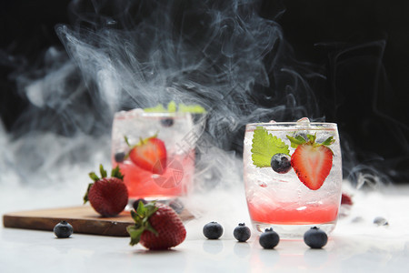 黑背景和烟雾上加冰薄荷的草莓果汁鸡尾酒图片