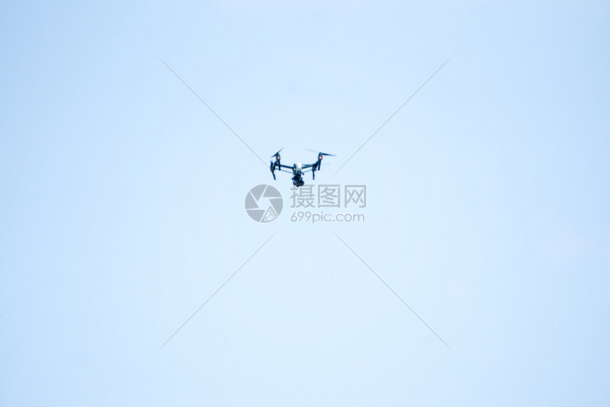 在蓝天背景下飞行的无人驾驶机图片