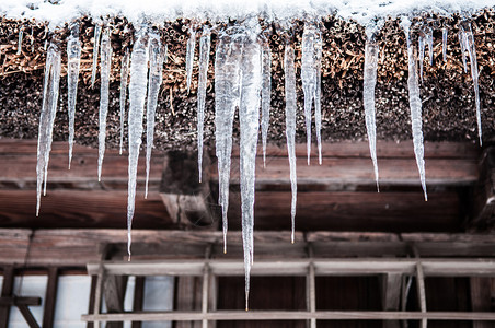 在日本冬天的冰棒挂在屋顶的阴沟上图片