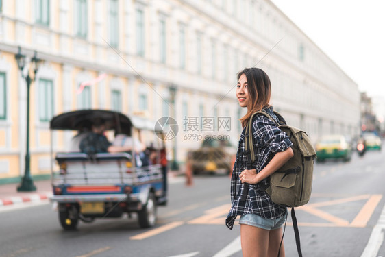 快乐的年轻女在惊人的地标度假享受传统城市的旅程图片
