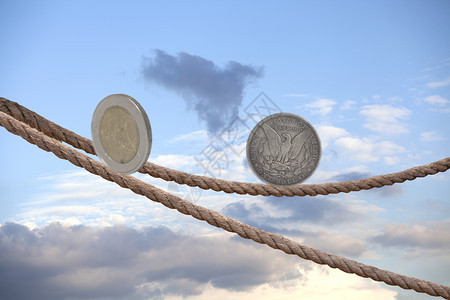 2欧元硬币和1美平衡在空中的绳索上平衡在天空的绳索上图片