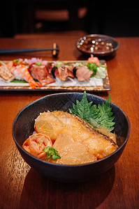 饭碗和木制餐桌上的混合寿司图片