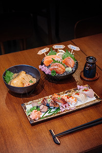 餐桌上的陶瓷板多种日本食品餐桌上的陶瓷板牛肉鹅草乌托罗虾牛肉舌汤布里大米和鲑鱼生菜图片