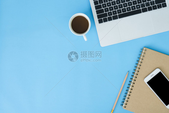 办公桌工作空间平面工作空间模拟照片用笔记本电脑智能手机咖啡和文具拍摄蓝面糊背景的工作空间图片