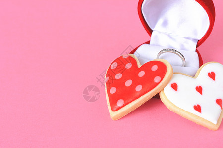 动图红盒中的两个心脏饼干和结婚戒指粉红色背景的复制空间情人节日概念背景