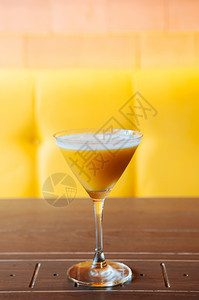 甜芒果汁冰在棕黄色背景的木桌上用美丽鸡尾酒杯图片