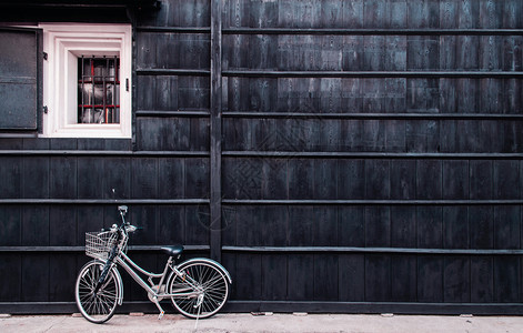 依靠在日本古老房屋墙边的自行车图片