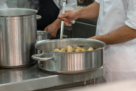 在餐馆的商业不锈钢厨房里做饭的师图片