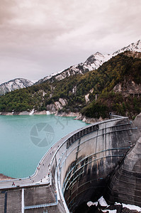 山与绿色的土库伊斯湖之间Kurobe大坝的自然景象这是Tateymkurobe高山路线的一部分图片