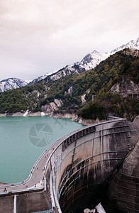 山与绿色的土库伊斯湖之间Kurobe大坝的自然景象这是Tateymkurobe高山路线的一部分图片