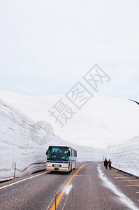 日本雅潘的公交行驶于雪墙之间道路视图图片
