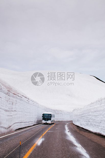 日本雅潘的公交行驶于雪墙之间道路视图图片