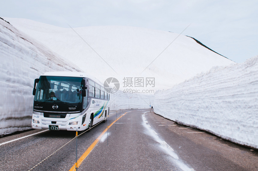 日本雅潘的公交行驶于雪墙之间道路视图图片