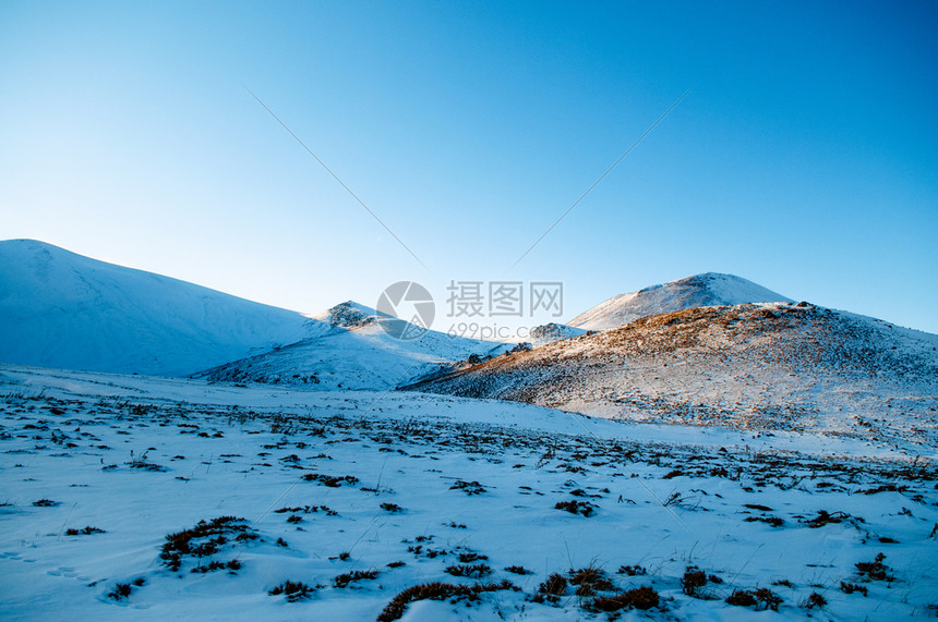 冬季在晴天的上满是雪的火山黑色和白的图像图片