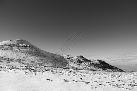 冬季在晴天的上满是雪的火山黑色和白的图像图片