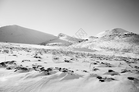 冬季在晴天的上满是雪的火山黑色和白的图像图片