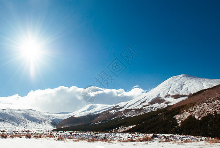 冬季在晴天的上满是雪的火山黑色和白的图像图片