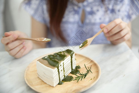 绿茶蛋糕年青的轻女人吃绿茶便蛋糕甜食背景