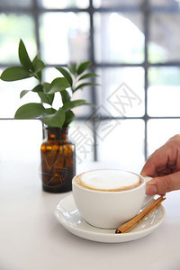 卡布奇诺咖啡手放在白色背景的手图片