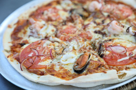 海鲜披萨与贝壳鱿鱼虾和番茄意大利菜图片