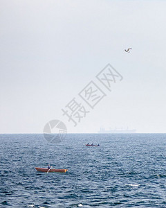 开渔节海景渔船在开放的蓝海中游出景夏季日在地平线上有一艘模糊的商船渔在蓝开海背景上看到油轮在地平线上模糊背景