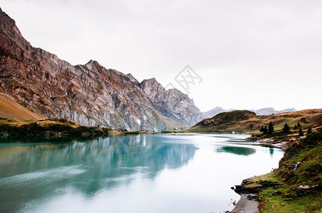 在Trubse湖岸边有小屋的农村风景观Swisalp在背景上爬着克劳山峰在安格尔堡的Titls山脚图片