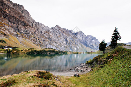 在Trubse湖岸边有小屋的农村风景观Swisalp在背景上爬着克劳山峰在安格尔堡的Titls山脚图片