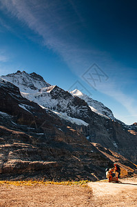 游客徒步旅行和全景色从瑞士的丛林地区jungfra地区Eigerltschr看到岩石悬崖和jungfra山峰图片