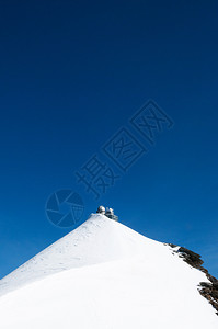 屹立在雪上顶部的建筑和蓝色天空背景图片