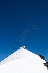 屹立在雪上顶部的建筑和蓝色天空图片