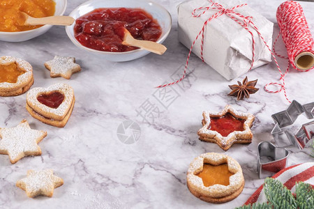 大理石表面的圣诞饼干带有装饰松树枝果酱礼品和饼干切图片