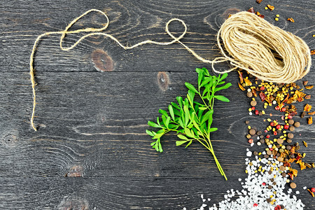带盐胡椒fenugrk种子和绳的新鲜绿色果与黑木板作对图片