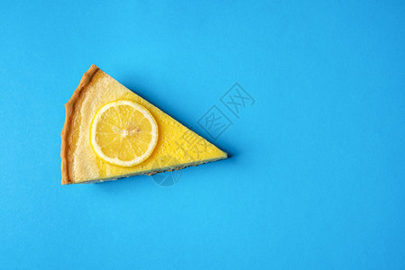 黄色柠檬蛋糕片配有柠檬蓝底直接在视野上方微小的风格美味水果甜点图片