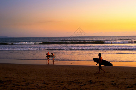 海滩上的冲浪者在风景日落巴利印地安图片